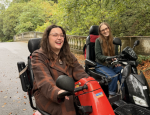 Two white woman, using trampers at an outdoor park.