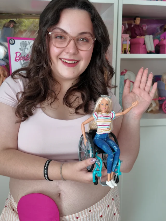 The countdown to World Stoma Day on the 3rd October is on!
Me and Barbie are getting ready...VD: A white woman with brown hair, wearing a pink top and pink stripe trousers. She has a stoma bag on show, with a pink cover on. She is holding a Barbie in a wheelchair, with Barbies in the background on shelves.