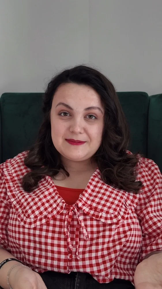 This World Arthritis Day let's spread some awareness about how the condition can affect young people.VD: A white woman, with brown curled hair, wearing red lipstick. Her outfit consists of a red gingham top with a peter pan collar and a red vest top underneath. She is sitting directly in front of the camera, talking.